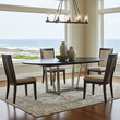 © Ray - A dining room is staged with a dark oval table surrounded by four chairs, and a modern chandelier. A large window offers an ocean view. Neutral colors are dominant.