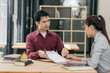 © ArLawKa - Real estate agents show clients home plans in a conference room. Buyers sign business contracts in a home office and discuss saving money on renting, buying a mortgage or home insurance.
