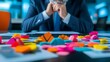© muhammad gunawan - A businessman sits pensively at his desk, colorful 3D charts and graphs scattered before him, suggesting strategic planning or data analysis