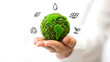 © SBD - Person holding a green earth symbol with icons of environmental sustainability