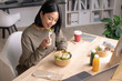 © amenic181 - Asian woman eating healthy meal while working, Businesswoman having a lunch break at the office
