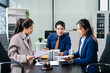 © Nuttapong punna - Professional business team discussing legal documents, contracts, and property models in an office
