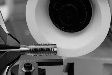 Poster - Machine with abrasive white disk used for sharpening milling cutter tool, industrial concept background