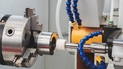 Poster - Industrial sharpening machine with large abrasive white disc close-up sharpening round metal part, industrial conceptual background