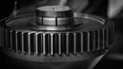 Poster - A close up of a gear with a black and white filter. Concept of precision and complexity, as gears are often used in machinery and other mechanical systems. black and white filter adds a timeless