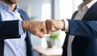 © photostockatinat - Business colleagues doing a fist bump gesture, showing team work and agreement. The image is taken in a business environment and shows two man doing a fist bump