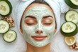 © Saya - Relaxed young woman getting facial care by professional beautician at spa salon, receiving face peeling mask for skincare