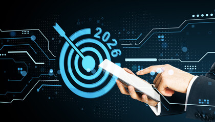 Fototapete - Businessman using tablet with digital target and 2026 goal symbol on futuristic background representing innovation and strategic vision.