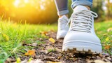 Close-up of white sneakers walking on a dirt path in a sunny outdoor setting