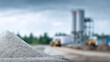 © Nakarin - Pile of gray concrete mix with construction site background cloudy sky, showing industrial environment and building materials, creating sense of ongoing development and construction activity