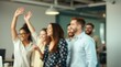 © Megono - Blurred image of a group of diverse office workers celebrating with raised hands and smiles