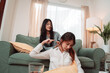 © Kiattisak - Asian Woman Home Massaging Shoulder Spa Treatment Wellness Togetherness Therapy, Serene Moment of Care and Connection as Two Friends Share Relaxation and Support in a Cozy Living Room Setting