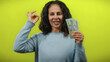 © Krakenimages.com - Middle-aged woman holding australian dollars meditates confidently against a vibrant yellow wall, embodying calm financial success and mindfulness.