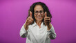 © Krakenimages.com - Woman smiling confidently with curly hair giving thumbs up against vibrant purple background showing positivity and success.