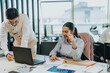 © qunica.com - Two business employees working together in a modern office setting, discussing ideas and analyzing data on a laptop, fostering teamwork and professional collaboration.