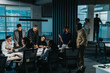 © qunica.com - A diverse and multigenerational team of business people engaged in a lively brainstorming session, fostering teamwork and creative thinking in a contemporary office environment.