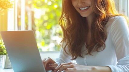 Wall Mural - a woman sits at a table with a laptop open, typing away