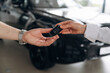 © standret - Purchase is successful. Detailed view of hands of customer that is taking keys for new purchased car