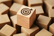 © tonstock - A wooden cube marked with a target icon symbolizes strategic decision-making and business focus amid scattered blocks representing challenges and growth opportunities
