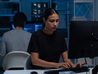 young hispanic female software developer working on computer for coding software program in office. 