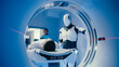 © ihorvsn - Humanoid robot standing beside MRI tunnel while observing Caucasian man lying still on examination table. Scene captured from inside scanner showing futuristic healthcare technology monitoring patient