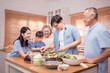 © Wosunan - Happy Asian family preparing food together in a bright kitchen,