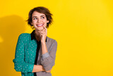 Photo of minded lovely girl wear trendy dotted print clothes look empty space isolated on yellow color background