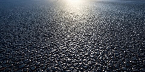 Aufkleber - A Detailed Close-Up View of a Dark Asphalt Surface with Light Reflecting off its Textured Surface