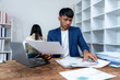 © Wicitr - Focused Businessman Reviewing Documents at Desk