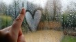 © Anna - Hand drawing heart on rainy window glass for romantic weather concept