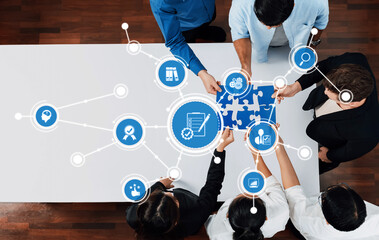 Aufkleber - A top-down view of a diverse group of professionals engaged in puzzle-solving, symbolizing collaboration and innovative strategies in a modern workspace environment. Amity