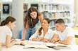 © JackF - Group of students talking, reading books and taking notes at table in library