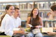 © JackF - Group of students sits in the library with books, they read and prepare for exams. Classmates prepare for the thesis together