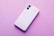 © Vitalii - Close-up of a smartphone with a white blank mock up case on a clean purple background
