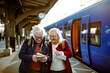© Davor - Senior women using map at train station while traveling together