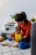 © Jovo Jovanovic/Stocksy - Woman with daughter reading picture book at home