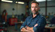 © Vadym - Mature mechanic in garage workshop portrait. Experienced man with crossed arms looking at camera. Repair, maintenance service work. Repairman specialist auto mechanic smiling, satisfied with his job.