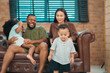 © chokniti - Heartwarming family moment as an African American father and daughter share playful time together on the couch, surrounded by love, laughter, and the warmth of home, while mom gently looks on with joy