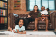 © chokniti - Heartwarming family moment as an African American father and daughter share playful time together on the couch, surrounded by love, laughter, and the warmth of home, while mom gently looks on with joy