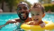 © Vadym - Joyful moment father son swimming pool. Happy mixed race father, child in inflatable ring smile. Summer fun vacation. Child swims with dad. Recreation, leisure, childhood joy together. Aquatic time.