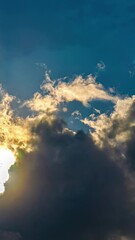 Wall Mural - Bright Sunlight Behind Moving Dense Clouds In Blue Sky. Timelapse