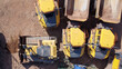© Dave Wall/Stocksy - Aerial top down view of quarrying vehicles parked by a field