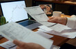 © Danil Nevsky/Stocksy - Businessman analyzing financial documents and charts on laptop