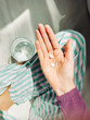 © Maryanne Gobble/Stocksy - Hand Holding Pills and Glass of Water