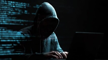 mysterious hacker working on laptop in dark room