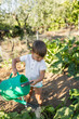 © Lupe Rodriguez/Stocksy - Little Boy Watering Vegetable Garden