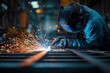 © oksa_studio - Welder using welding machine creating sparks while working on steel structure in industrial environment