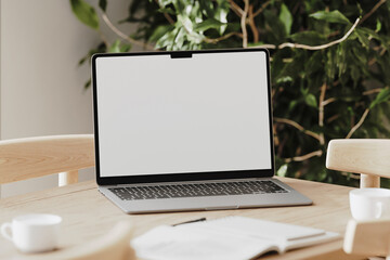 White laptop screen mock-up on a wooden desk