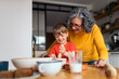 © Santi Nuñez/Stocksy - Grandmother and grandson baking together in the kitchen
