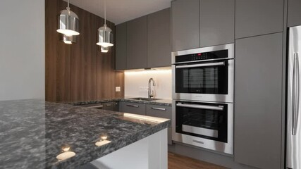 Poster - Modern kitchen with sleek gray cabinets, marble countertop, built oven, stainless appliances, pendant lights, and cozy wood